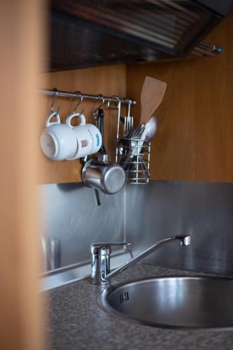 a kitchen sink with two coffee cups on a rack at sunsetview1 studios in Batsi