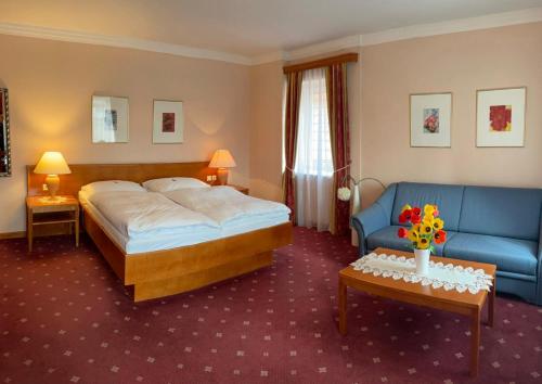 a hotel room with a bed and a couch at Landgasthof zur Post in Mitterdorf im Mürztal