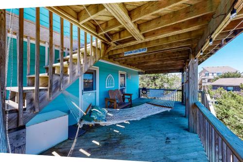 a porch of a blue house with a hammock at Happy Ours in Salvo