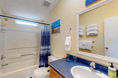a bathroom with a sink and a toilet and a mirror at Lighthouse View in Lincoln City