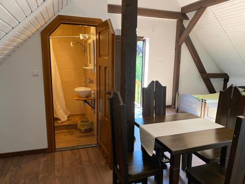 a dining room with a table and a bathroom at Mazurska Zagroda in Rydzewo