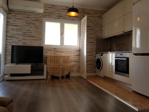 a kitchen with a table and a television in a room at Oro Apartments Tirana in Tirana