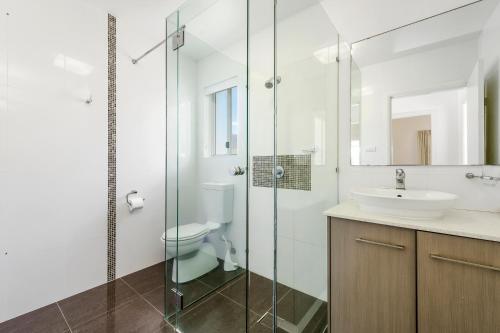 een badkamer met een glazen douche en een wastafel bij H2O Holiday Apartments Unit 5 in North Haven