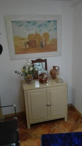 a table in a room with a painting on the wall at Comporta Family House in Comporta
