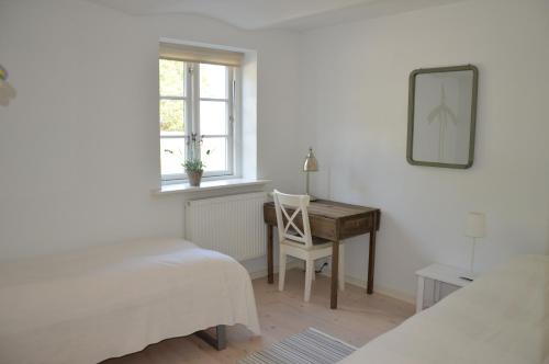 een slaapkamer met een bureau, een stoel en een spiegel bij Svendlundgaard Apartments in Herning