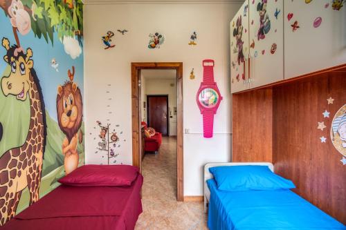 two beds in a room with giraffes on the wall at SWEET HOME LULLABY - free parking in Passoscuro