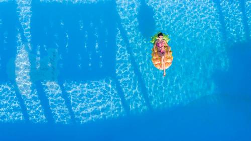 a person is sitting on a pineapple in the water at Hotel Lido degli Scogli in Crotone