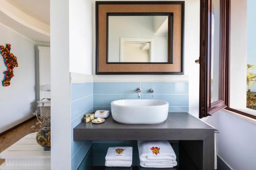 bagno con lavandino e specchio di Hotel Lido degli Scogli a Crotone