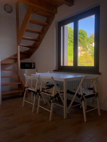 een tafel en stoelen in een kamer met een raam bij Barcola mare apartment in Trieste