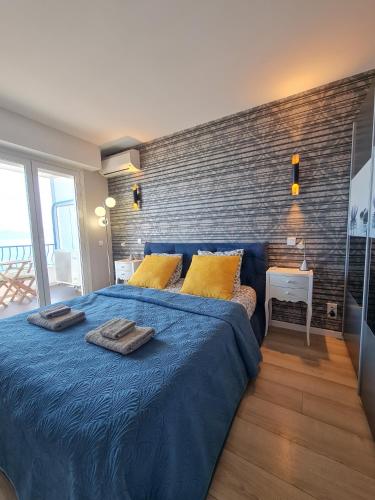 une chambre avec un lit bleu et un mur de briques dans l'établissement Western Cannes - Panoramic View, à Cannes