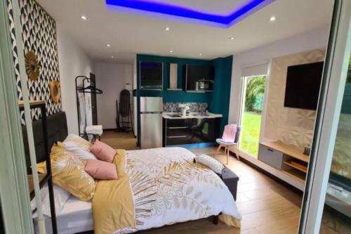 een slaapkamer met een groot bed en een keuken bij Studio chic et cosy in Cayenne