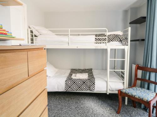 a bedroom with two bunk beds and a chair at 9 Navigation Square in Skipton