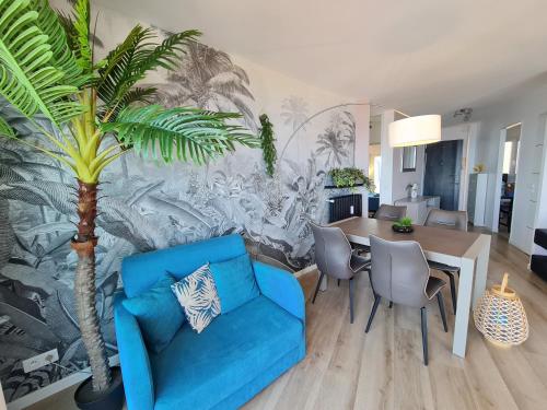a living room with a blue couch and a palm tree at Western Cannes - Panoramic View in Cannes