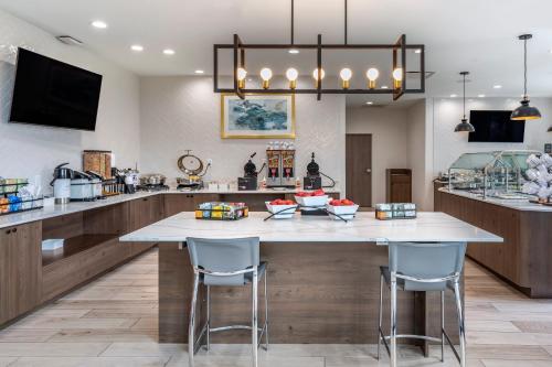 a kitchen with a large white island with bar stools at Staybridge Suites Grand Prairie Near Epic Central by IHG in Grand Prairie