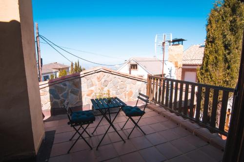 a patio with two chairs and a table on a balcony at Cumbres Verdes Rural in Granada