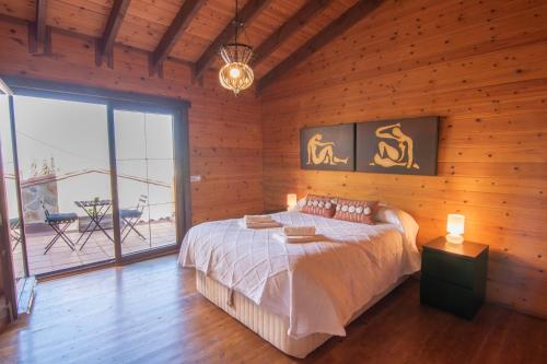 a bedroom with a bed in a wooden wall at Cumbres Verdes Rural in Granada