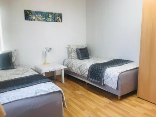 a bedroom with two beds and a table with a lamp at PensionLien in Köthen