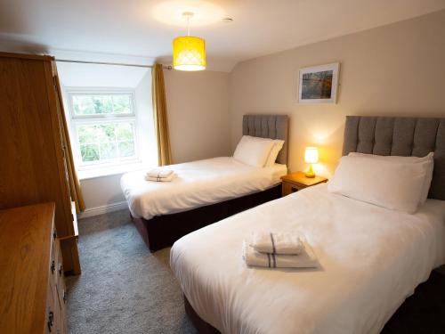 a bedroom with two beds and a window at Hafan in Llangollen