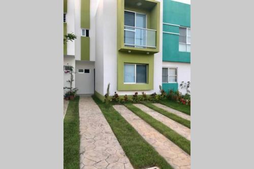 a house with a lawn in front of it at Puerto Morelos - House to enjoy Riviera Maya in Puerto Morelos