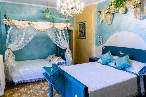 twee bedden in een kamer met blauwe muren bij Bellavista Versilia in Pietrasanta