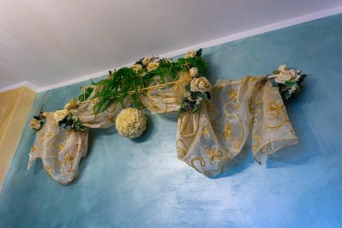 a blue wall with a group of towels with flowers at Bellavista Versilia in Pietrasanta