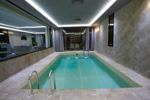 a swimming pool in the middle of a building at الأيبنوس EBONyشالية فندقي بصالة سينما ومسبح بجهاز تدفئة in Khamis Mushayt