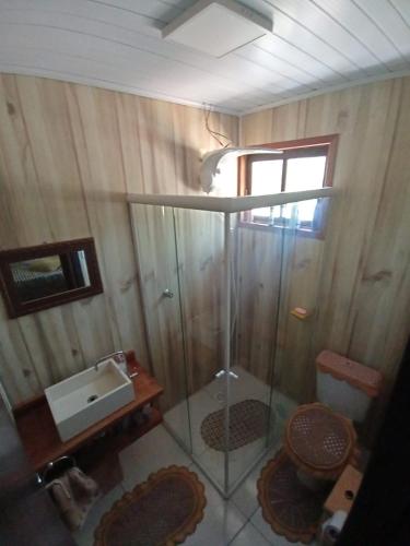 a bathroom with a shower with a sink and a toilet at Casa de Campo da Vó in Urupema