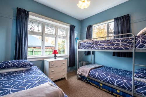 a bedroom with two bunk beds and two windows at 5 Amuri Avenue in Hanmer Springs