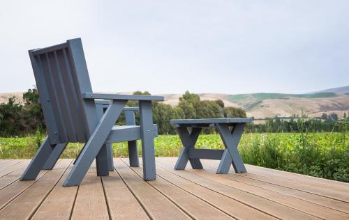 a pair of benches sitting on a wooden deck at Honey Cottage in Ettrick in Millers Flat