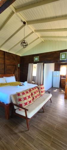 a bedroom with a large bed and a bench at Wilton House Oceanview Cabin in Mearnsville