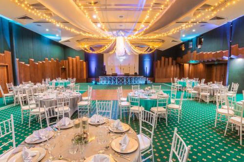 a banquet hall with white tables and chairs at GHL Hotel Sunrise in San Andrés