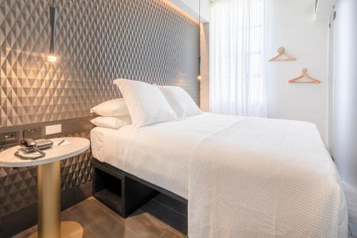 a bedroom with a white bed and a table at Castlereagh Boutique Hotel, an Ascend Collection Hotel in Sydney