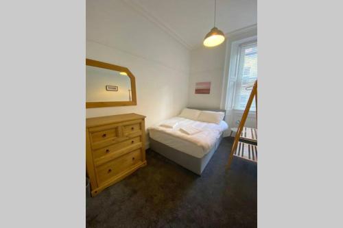 1 dormitorio con cama, tocador y espejo en 300 yards from Old course and St Andrews centre en St Andrews