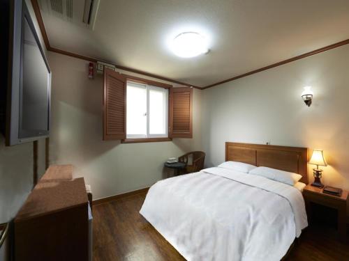 ソウルにあるノーブル ホテルのベッドルーム(大きな白いベッド1台、窓付)