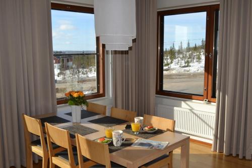 a dining room with a table and chairs and a window at Ylläs Chalets A9206 Talvikaudelle 25-26 hinta sisältää 2kpl hissilippuja! in Ylläsjärvi