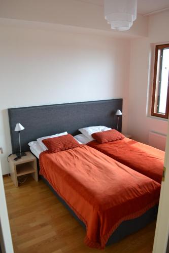 - une chambre avec 2 lits avec des draps rouges et une tête de lit dans l'établissement Ylläs Chalets A9206, à Ylläsjärvi