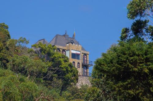 a house on top of a hill with trees at The Wind Castle in Nuwara Eliya