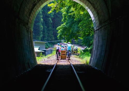 a tunnel with two people riding bikes on train tracks at 筋肉と自然と遊ぶ宿 田島館 in Takayama
