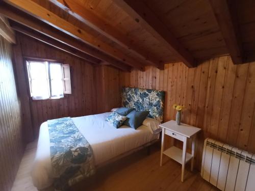 カンガス・デ・オニスにあるCasa Rural La Cabañaの木製の部屋にベッド1台が備わるベッドルーム1室があります。