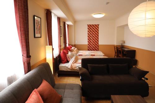 a living room with a couch and a bed at ケイアイコンホテルズ 新栄301 in Aoichō