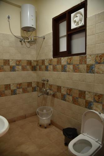 a bathroom with a toilet and a sink at Mastiff Wildcrest Outer Dharamshala Near Chamunda Devi Temple in Pālampur