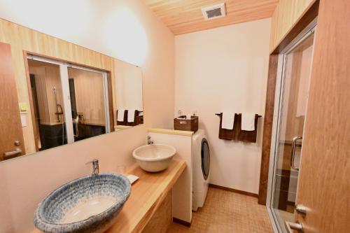 y baño con lavabo y aseo. en Manabi-stay Takayama SAKURA 提携駐車場利用可 古い町並みまで徒歩1分 最大9名宿泊可能な一等地で人工温泉を楽しむ, en Takayama