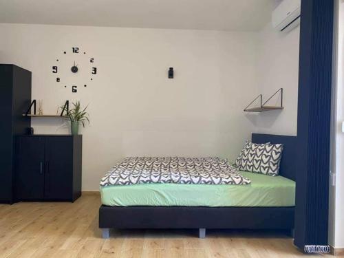 a bedroom with a bed and a clock on the wall at Apartma Šelih Mandre - Pag in Mandre