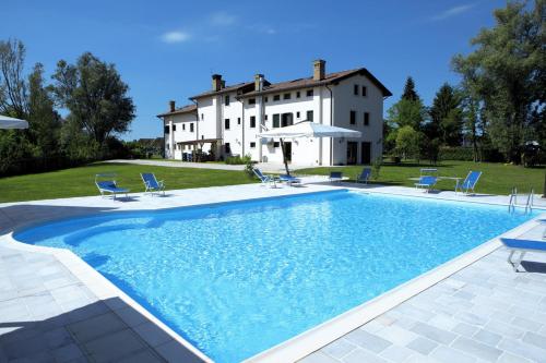 a large swimming pool in front of a house at Le Favole Agriturismo in Sacile