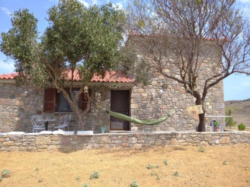 a stone house with a green hose in front of it at Paliokaliva Home in Roussopoúlion