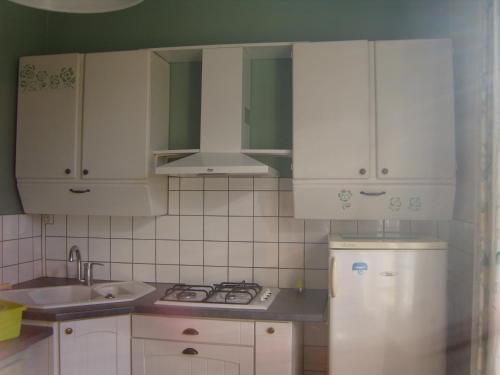 La cuisine est équipée de placards blancs, d'un évier et d'un réfrigérateur. dans l'établissement gite du vieux tilleul, à Fère-en-Tardenois