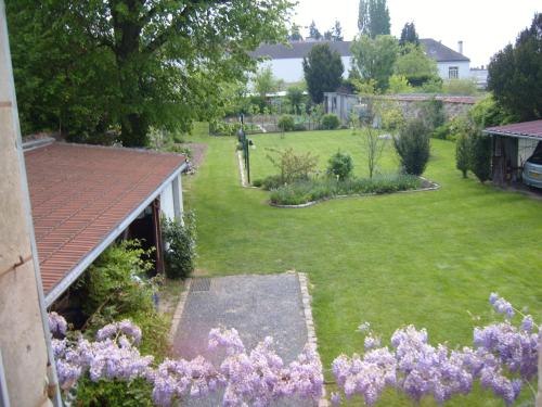 un jardin avec des fleurs violettes dans une cour dans l'établissement gite du vieux tilleul, à Fère-en-Tardenois