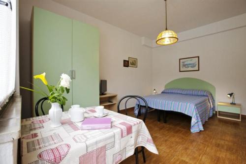 Cette chambre comprend une table et un lit. dans l'établissement Casa Augusta, à Maccagno Inferiore