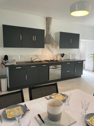 a kitchen with black cabinets and a table with food on it at Appartement cour ancienne abbaye in Saint-Astier
