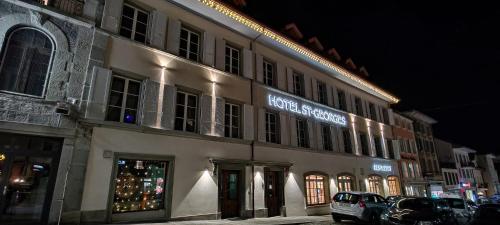 a building with a christmas tree in front of it at Hôtel St-Georges Romont in Romont